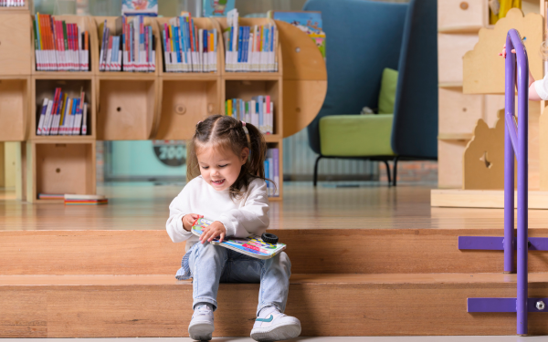 meisje met boek in bibliotheek